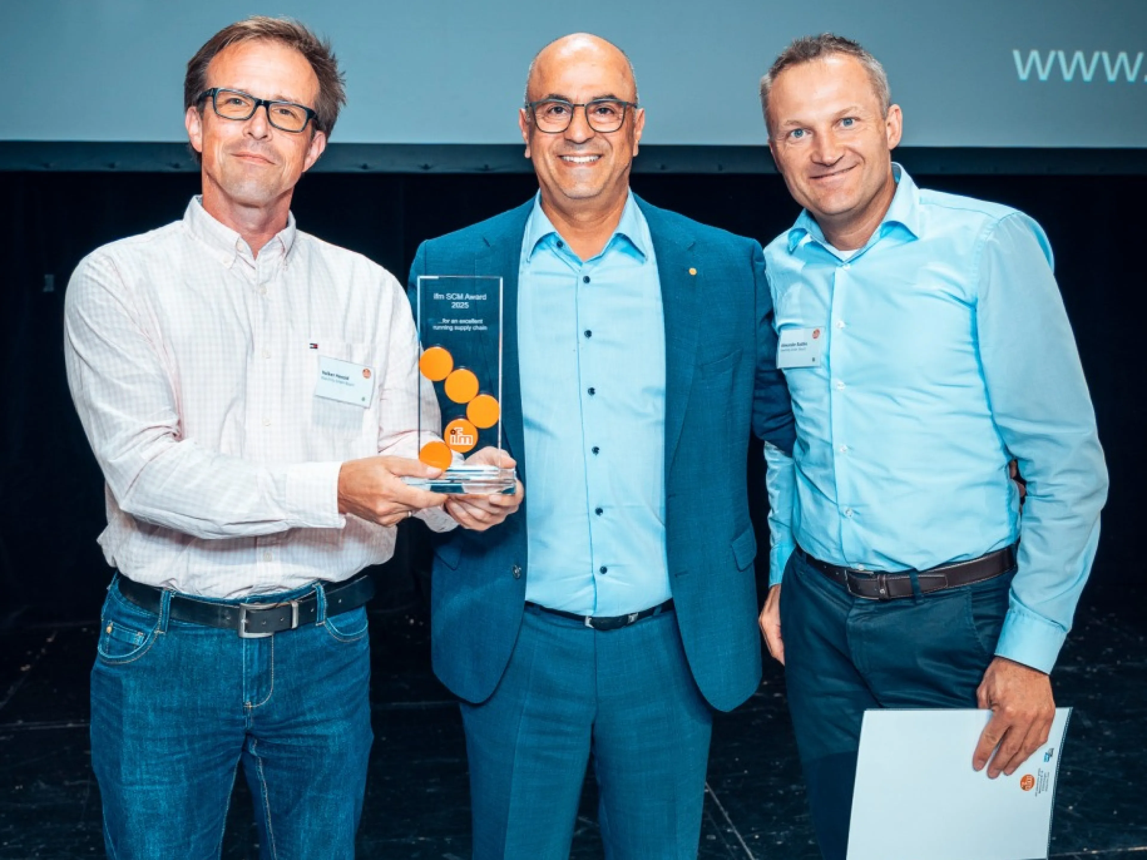 Bilgin Kilic (Mitte) vergibt den Ifm Supply-Chain-Management (SCM) Award für die schnellste Einführung an Volker Herold (l.) und Alexander Radtke (r.) von Keenfinity, einem Spin-off von Bosch Sicherheitssysteme, Bild: Ifm / Gerrit Bender Bilgin Kilic (Mitte) vergibt den Ifm SCM Award für die schnellste Einführung an Volker Herold (l.) und Alexander Radtke (r.) von Keenfinity, einem Spin-off von Bosch Sicherheitssysteme